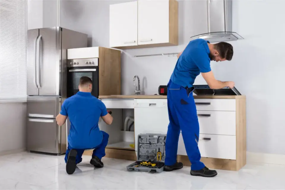 QA Playwright Plumbing technicians working on a kitchen sink and dishwasher installation
